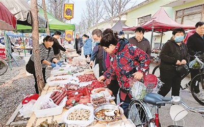 市民在北京市海淀區上莊水鄉大集上購買食品。蘇明辰攝